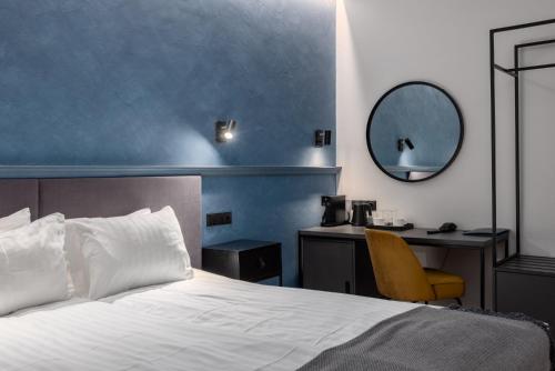 里加Konventa Sēta Hotel Keystone Collection的一间卧室配有一张床和一张带镜子的书桌