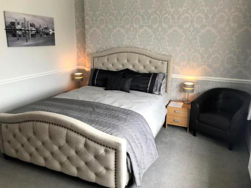 利物浦奥勒尔公园酒店的卧室配有白色的床和黑椅
