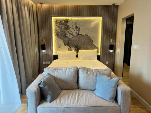 迪拜Deluxe - Address Dubai Mall - The Residence的一间卧室配有一张床和一张带枕头的沙发。