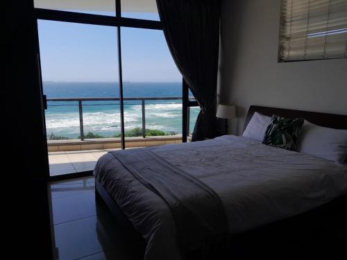拉莫西CoRAL REEF 207的一间卧室配有一张床,享有海景