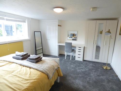伊利Windmill Cottage的一间卧室配有一张床、一张书桌和一个窗户。
