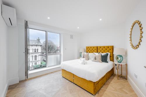 伦敦Flat 205的白色的卧室设有一张大床和一个窗户