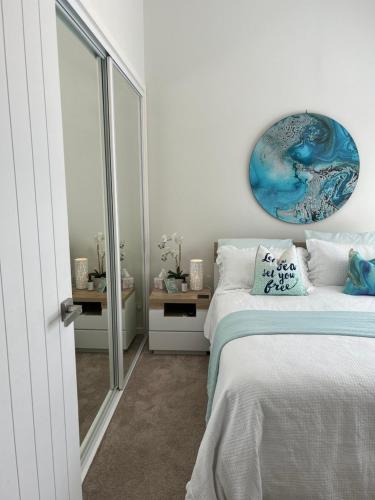 WoononaWoonona Family Beach Villa 2 bedroom Brand new的卧室配有一张床,墙上挂着一幅蓝色画作