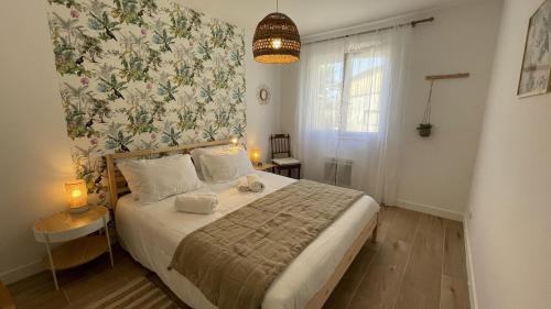 索尔古河畔的恩特莱奎斯Le Clos Du Moulin 3 - Maison et Jardin, proche Avignon en Provence的一间卧室配有一张带花卉墙壁的床