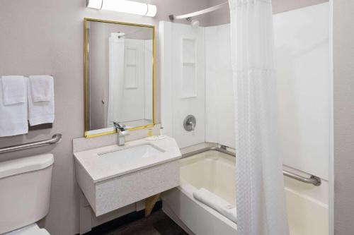 印第安纳波利斯印第安纳波利斯西北戴斯酒店的浴室配有盥洗盆和浴缸。