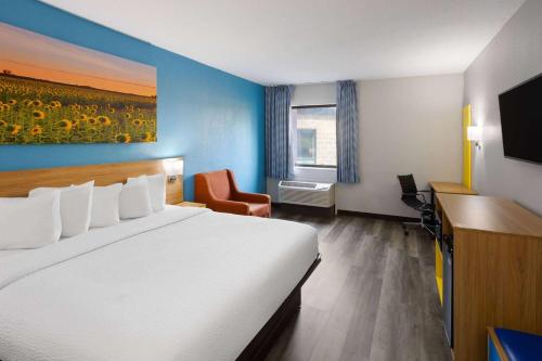印第安纳波利斯印第安纳波利斯西北戴斯酒店的配有一张床、一张书桌和一扇窗户的酒店客房
