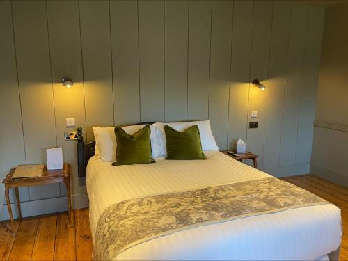 温坎顿Holbrook Manor & Spa - OCEANA COLLECTION的一间卧室配有一张带绿色枕头的大床