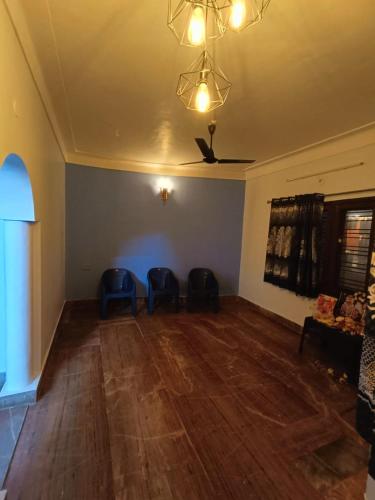 蒂鲁瓦纳马莱Agnisthala Guest House的一间空客厅,配有两把蓝色椅子和天花板