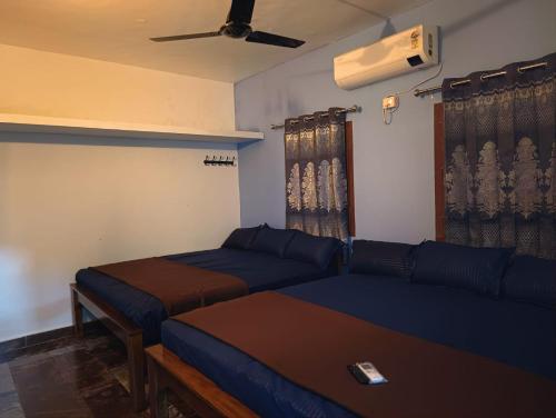 蒂鲁瓦纳马莱Agnisthala Guest House的一间带两张床和一张沙发的客厅