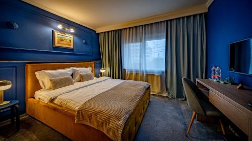 蒂米什瓦拉Hotel Cocó的一间卧室设有蓝色的墙壁、一张床和一张书桌