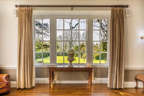 温坎顿Holbrook Manor & Spa - OCEANA COLLECTION的客厅设有大窗户和桌子