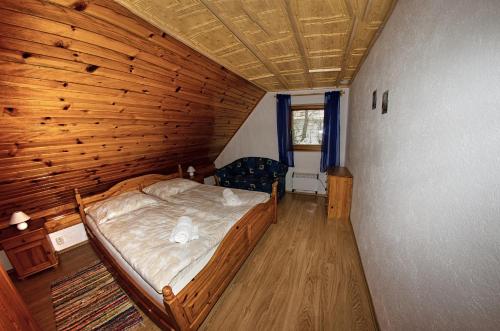 VažecApartmany pod Tatrami的木制客房内的一间卧室,配有一张床