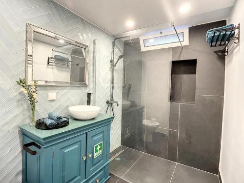 圣克鲁斯Casa da Horta by Atlantic Holiday的浴室设有蓝色橱柜、水槽和淋浴