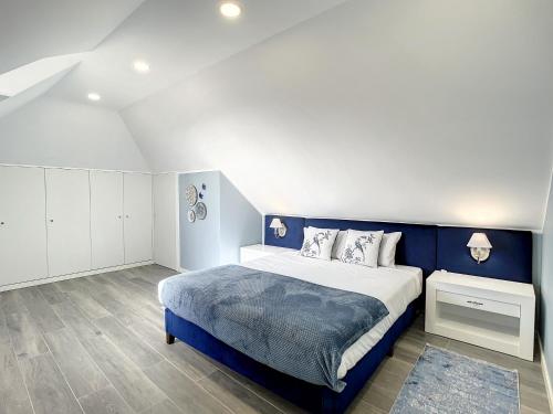 圣克鲁斯Casa da Horta by Atlantic Holiday的卧室配有蓝色和白色的床以及白色的橱柜。