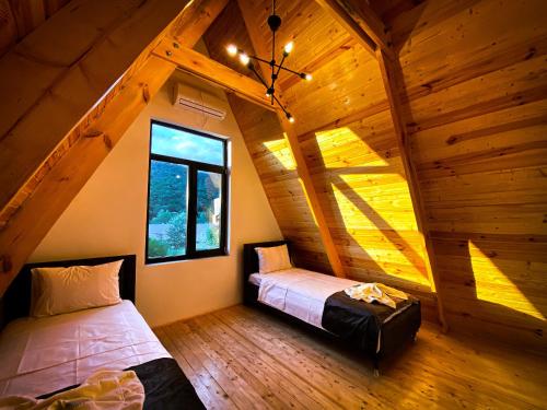 盖贝莱Qafqaz Royal Chalet的小木屋内一间卧室,配有两张床