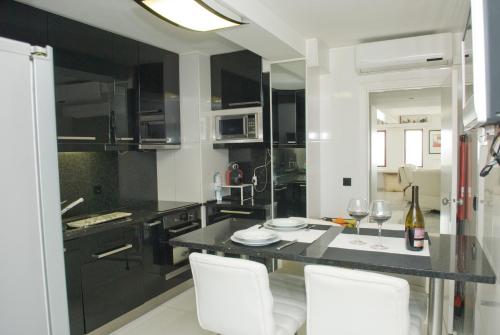 马托西纽什波尔图赛公寓的厨房配有黑色柜台和白色椅子