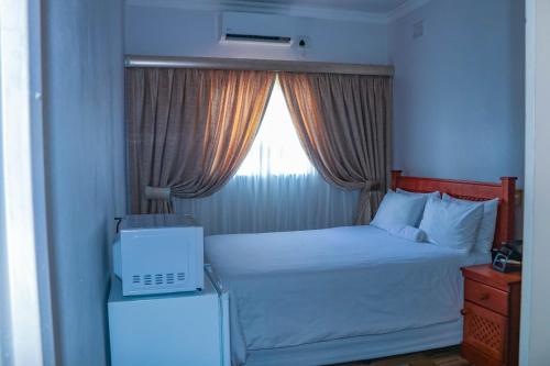 恩潘盖尼Mesda Bed & Breakfast的一间小卧室,配有一张带窗户的床