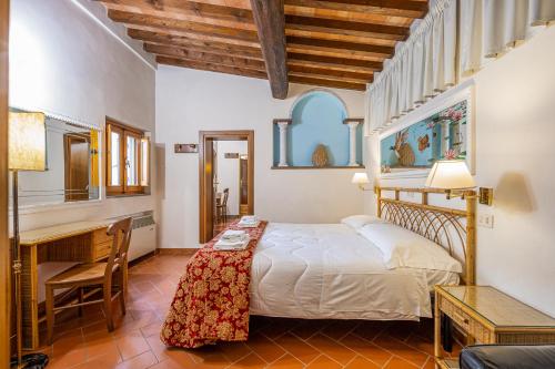 佛罗伦萨城市酒店的一间卧室配有一张床、一张书桌和一张书桌