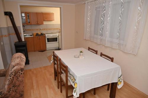 拉克塔希Domacinstvo Marija的厨房以及带白色桌椅的用餐室。