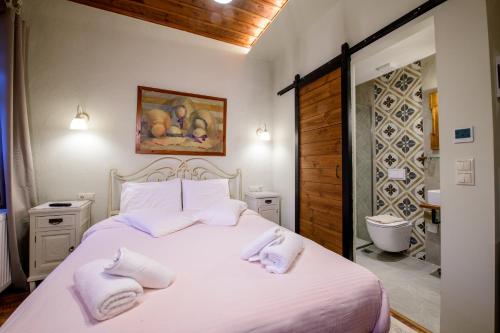 奥吉欧司吉玛洛斯Agios Germanos的卧室配有白色床和毛巾
