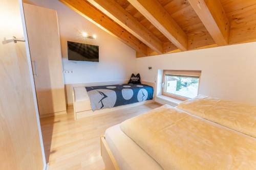 达米尔斯Haus Montana的卧室配有一张床,墙上配有电视。