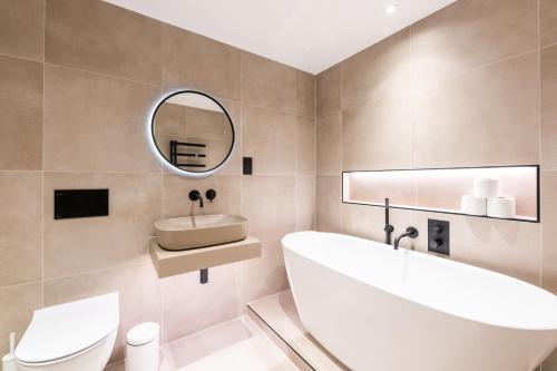 伦敦The Maida Vale的带浴缸、水槽和镜子的浴室