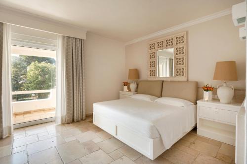 奥斯图尼Ostuni a Mare的白色的卧室设有一张大床和一个窗户