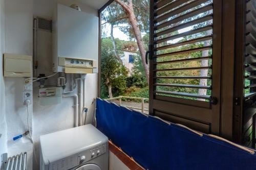 卡莱利亚德帕拉弗鲁赫尔Els Forcats的一间带洗衣机和窗户的浴室