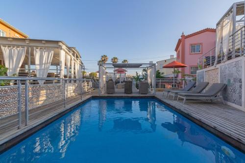 拉戈斯维拉斯D迪尼斯旅馆 - 迷人居所（仅限成人）的一座游泳池旁设有两把躺椅