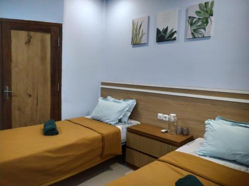 龙目岛库塔Merendeng Hostel Kuta的一间客房内配有两张床的房间