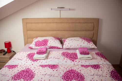 尼克希奇Apartman Mazić Nikšić的一张带粉色和白色床单及枕头的床