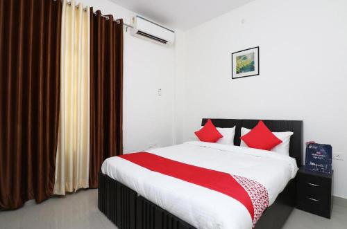 勒克瑙IIDM Eco Centre的一间卧室配有一张带红色枕头的大床
