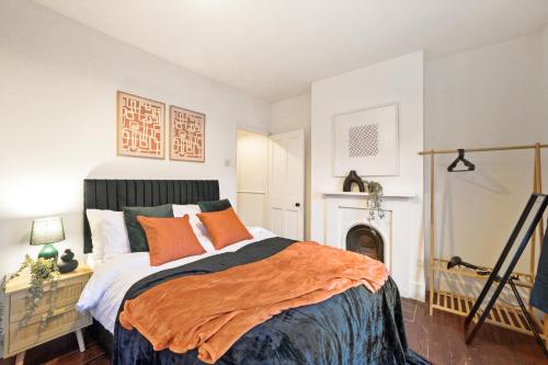 普拉姆斯特德Boutique London Abode - Games Room - Parking的一间卧室配有一张带橙色毯子的床