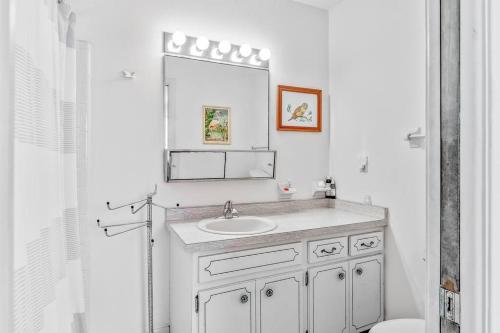 维洛海滩Cozy cottage for longer stays!的白色的浴室设有水槽和镜子