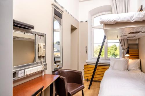 斯德哥尔摩STF朗霍尔曼旅馆的一间卧室配有双层床、书桌和电视。