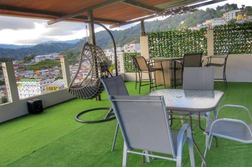 SololáApto Vista Hermosa con terraza ajardinada privada的绿地阳台配有桌椅