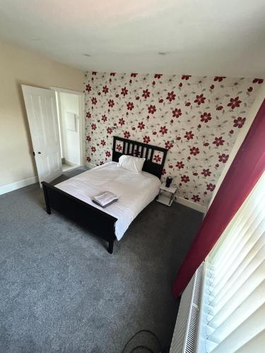 卡莱尔Canvas House的一间卧室配有一张带花卉壁纸的床