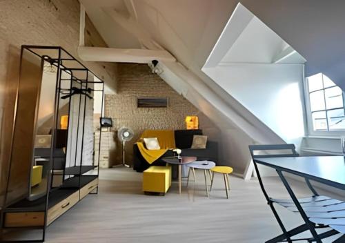 贝叶Studio au centre historique de Bayeux的阁楼客厅配有黄色和黑色的家具