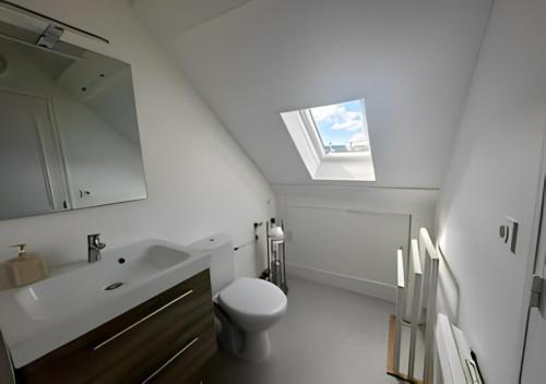 贝叶Studio au centre historique de Bayeux的一间带水槽和卫生间的浴室以及窗户。