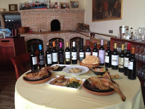 Pesquera de Duero拉波萨达德佩斯克拉宾馆的一张桌子,上面放着一束葡萄酒和食物
