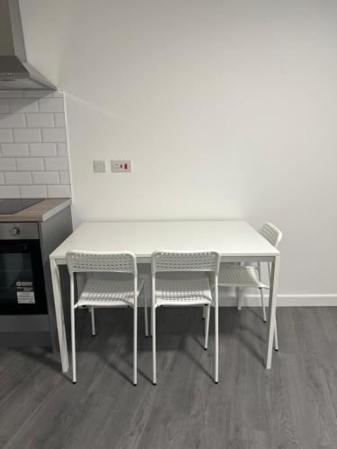 莱斯特London Rd Apartment's的厨房里配有一张白色的桌子和两把椅子