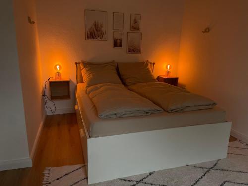 哈根Cozy Appartement Hagen的一间卧室配有一张带两个灯的床