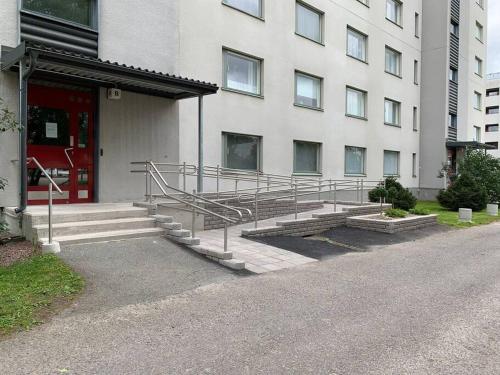 图尔库2 bedroom apartment, Turku的一座建筑前面设有红色的门和楼梯