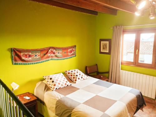 CadreitaCasa rural de la Abuela的一间卧室设有绿色的墙壁和一张带枕头的床