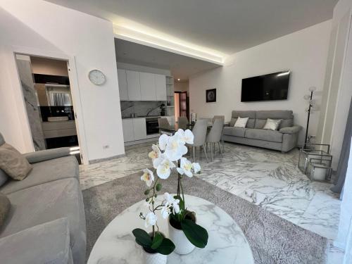 罗马马鲁帕之家豪华公寓的客厅配有白色花卉的桌子