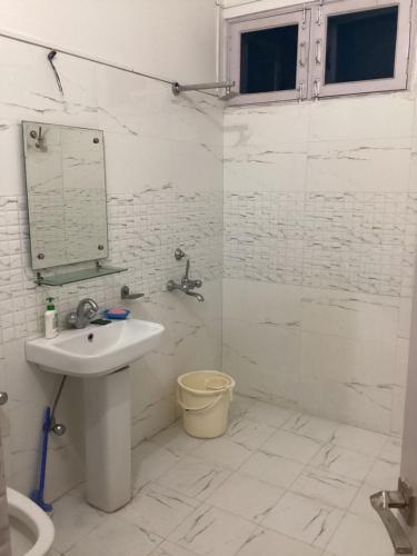 贾姆穆Trikuta Homestay的白色的浴室设有水槽和淋浴。