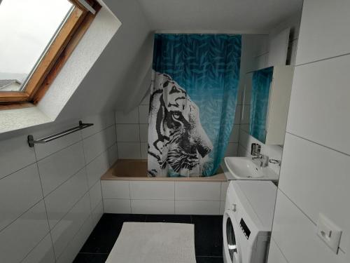 特林巴赫Butthouse Apartments的一间带老虎淋浴帘和水槽的浴室
