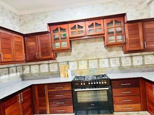 达累斯萨拉姆Oceans-Opulence/3BR-5 BEDS的厨房配有木制橱柜和炉灶烤箱。