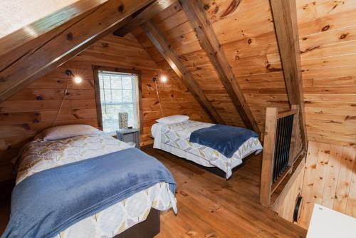 AudetLe Madison的小木屋内一间卧室,配有两张床