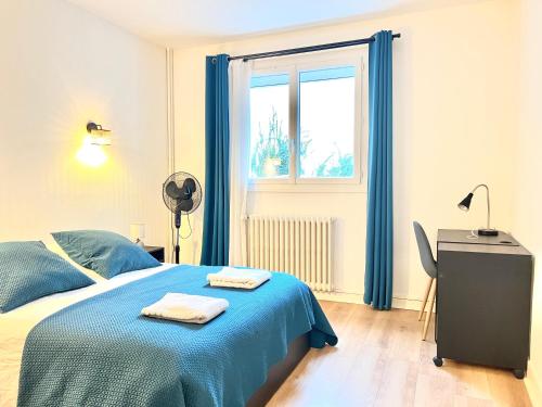 普瓦捷Stay house to Poitiers的一间卧室设有蓝色的床和窗户。